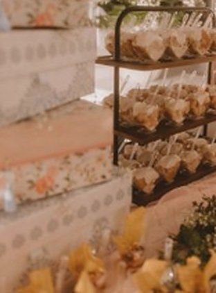 A dessert display with tiered shelves and floral boxes